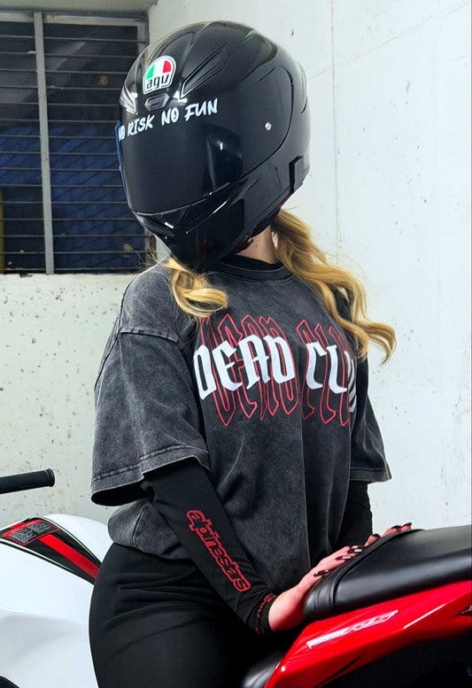 Person wearing a helmet and black outfit sitting on a red and white motorcycle.